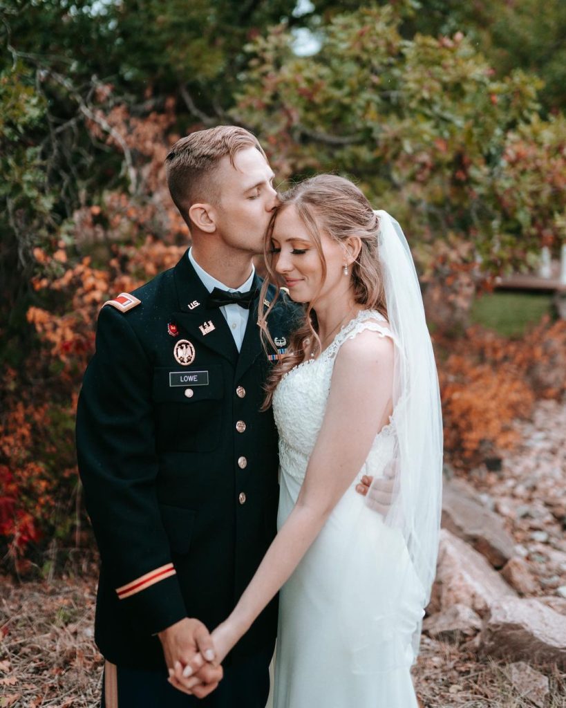 military wedding at creekside event center with groom kissing bride on forehead 819x1024